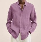 Close-up of the curved shirt hem falling over white trousers, showing the relaxed silhouette