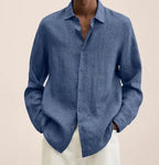 Front view of a mid-blue linen shirt with classic collar, shown buttoned with sleeves rolled to the wrist