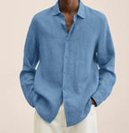 Close-up front view of a denim-blue linen shirt highlighting the natural fabric weave and curved hem