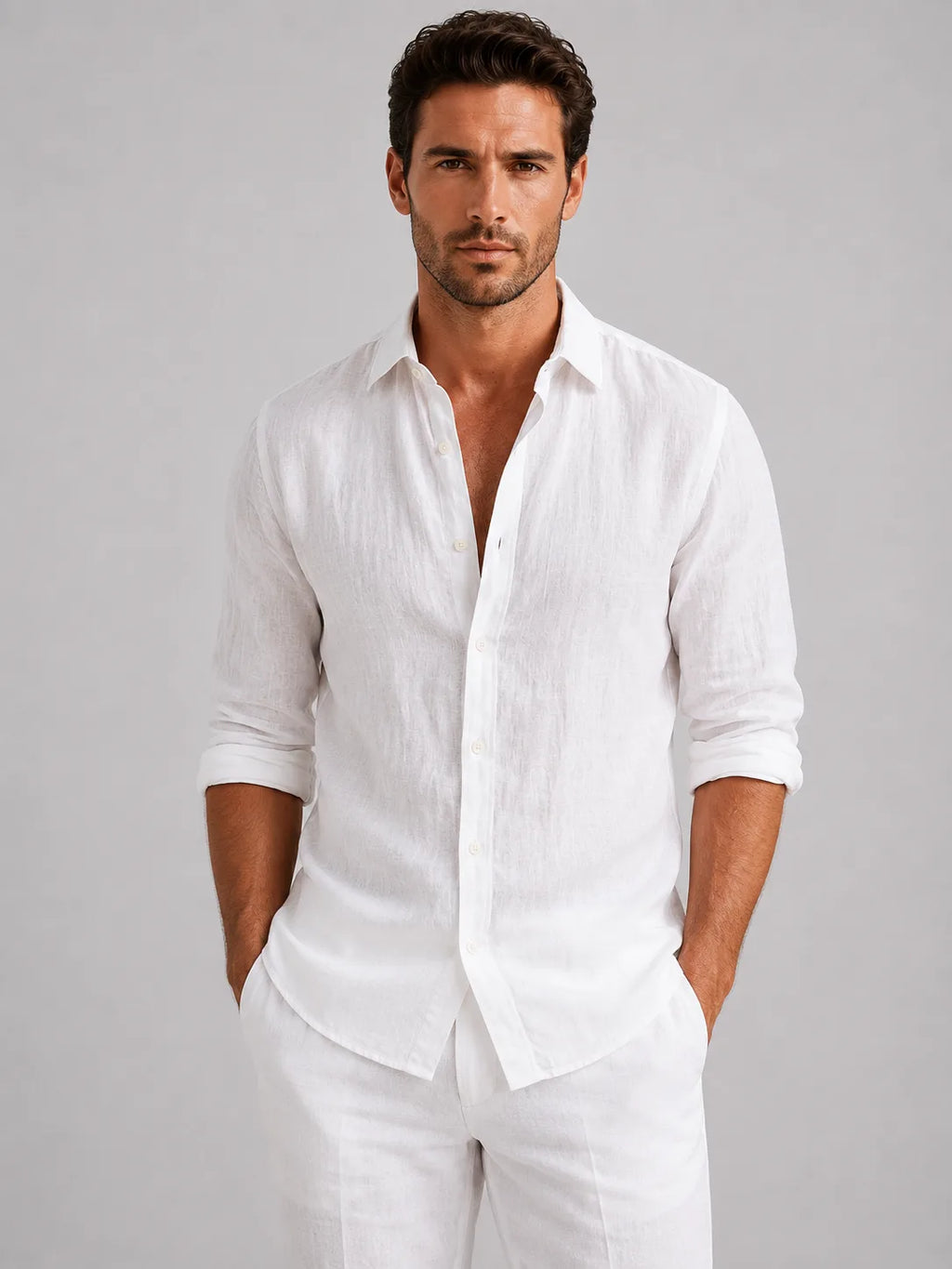 Man wearing a crisp white linen-look button-up shirt with rolled sleeves, styled with matching white trousers