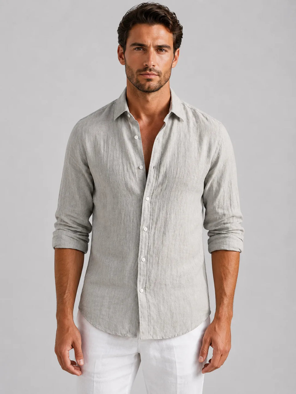 Man wearing a light grey linen-look button-up shirt with rolled sleeves, buttoned down over white trousers