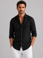 Front view of a man in an open-collar linen-look shirt showing the point collar and mother-of-pearl style buttons
