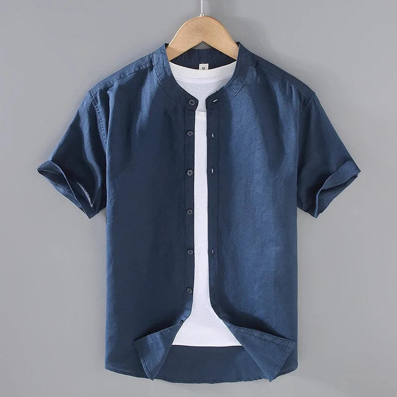 Close view of the stand collar and button placket on a pale blue linen short sleeve shirt