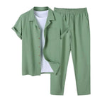 Sage green linen two-piece set with camp collar shirt and drawstring trousers, worn over a white t-shirt