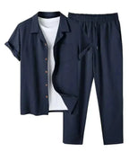 Navy blue linen shirt and trouser two-piece set with wooden buttons, laid flat over a white t-shirt