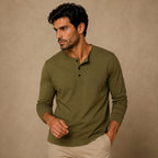 Man wearing olive green henley with button placket and relaxed fit, paired with beige chinos