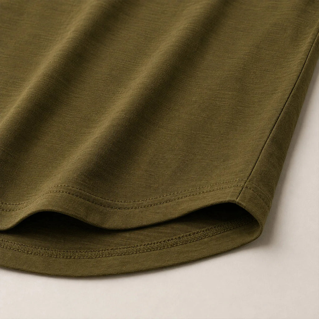 Close-up of the curved hem and soft cotton fabric texture on the olive green henley