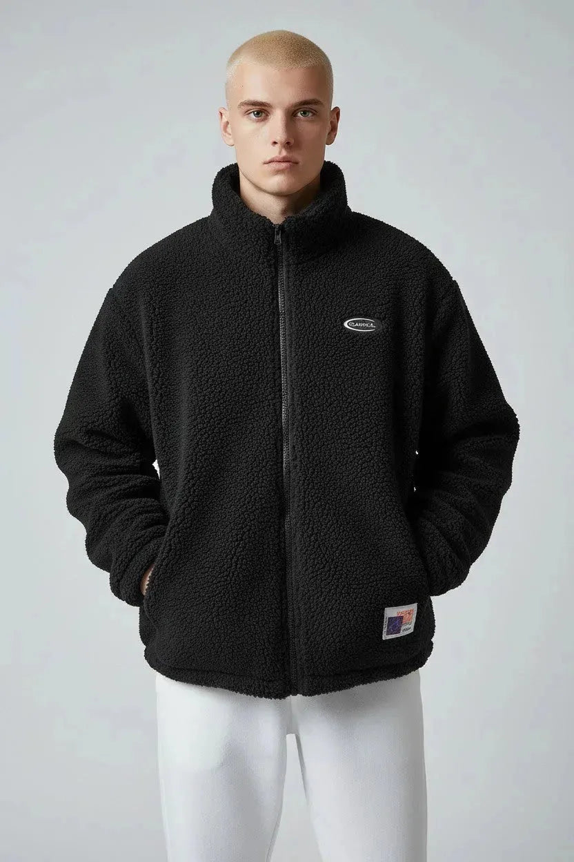 Front view of black textured sherpa fleece jacket with stand collar, full zip and chest logo badge
