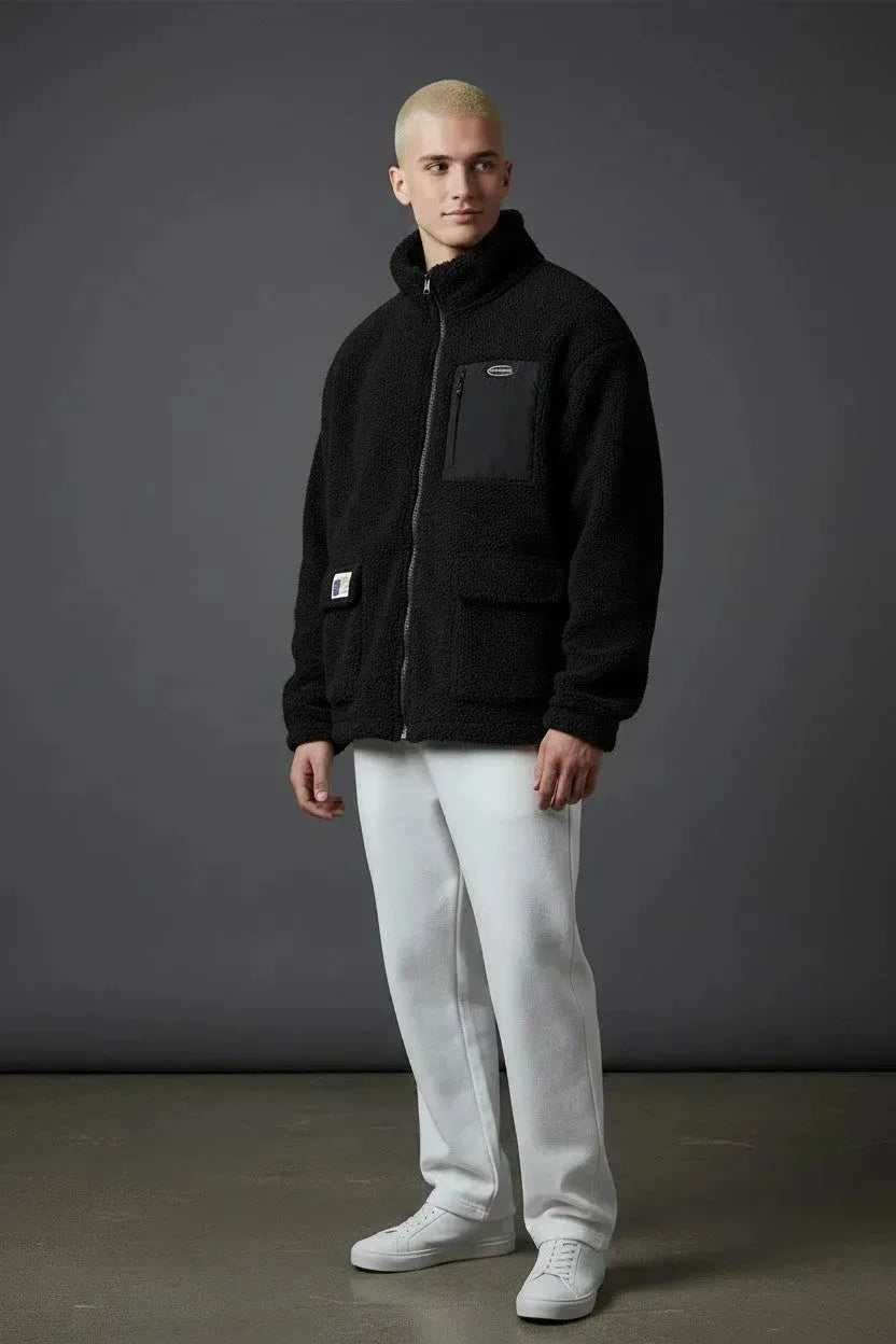 Full length view of black sherpa zip jacket styled with white pants and white sneakers