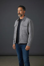 Side profile of a grey suede-effect trucker jacket worn open over a navy tee, showing collar and chest pockets.