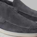 Top-down view of a taupe suede loafer showing the apron seam and suede grain