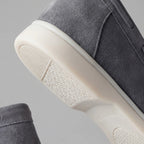 Close-up of the white rubber sole edge against the taupe suede upper