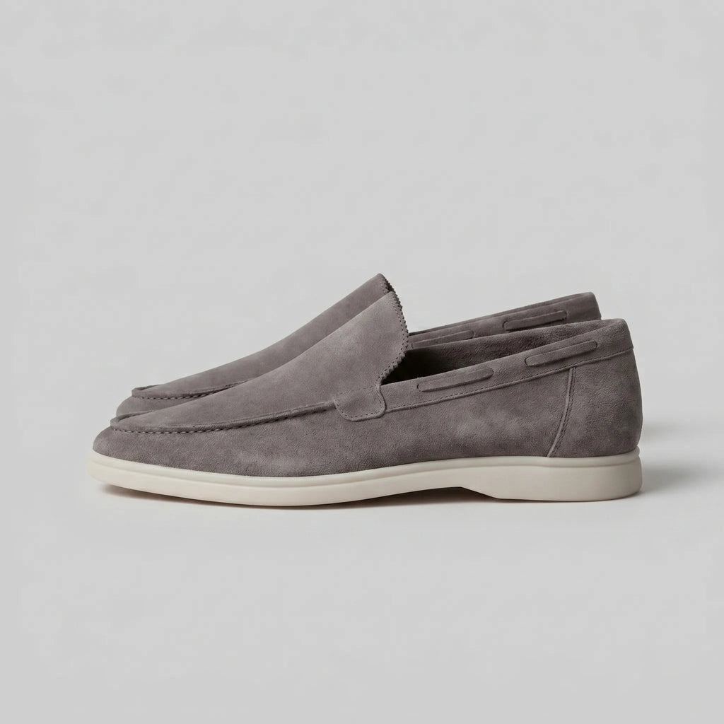 Close-up of the stitched collar and heel pull tab on a taupe suede loafer