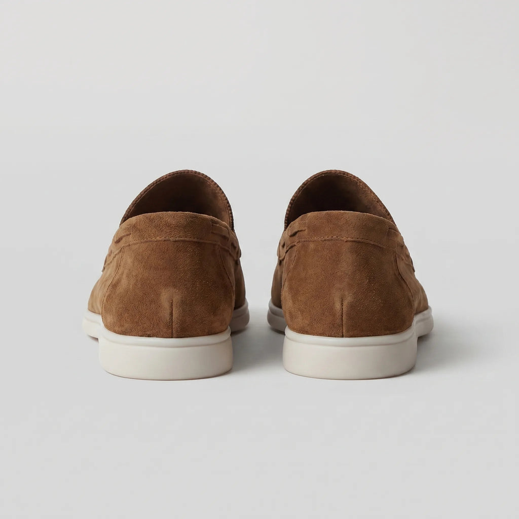 Front view of light grey suede loafers showing the rounded toe and apron stitch
