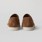Front view of light grey suede loafers showing the rounded toe and apron stitch
