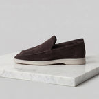 Close-up of the heel stitching detail on a light grey suede loafer
