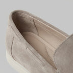 Close-up of the interior lining and padded heel collar of a taupe suede loafer