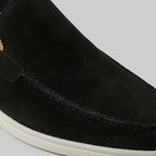 Rear view of dark brown suede loafers showing the white outsole and heel seam