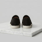 Top view of a dark brown suede loafer highlighting the moc-toe construction