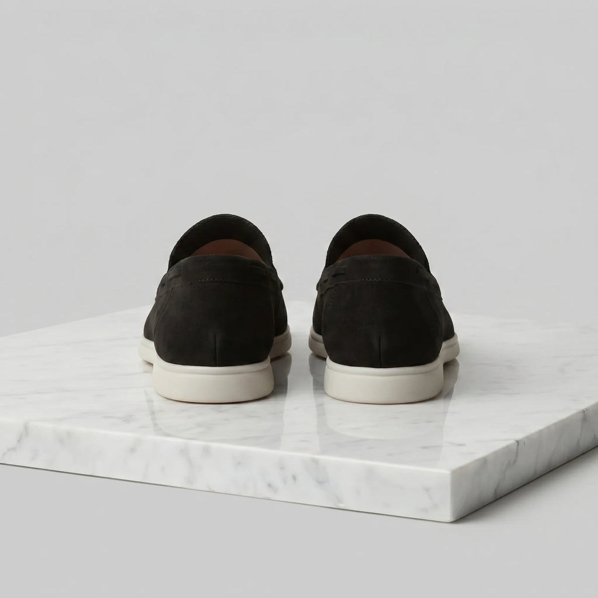 Top view of a dark brown suede loafer highlighting the moc-toe construction