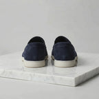 Close-up of the toe stitching and suede grain on a deep blue loafer with white sole