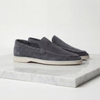 Front angled view of taupe suede loafers highlighting the rounded toe shape