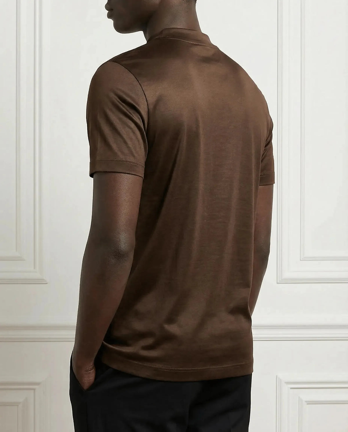 Side-back view of model wearing a brown mercerised cotton t-shirt with slim fit sleeves
