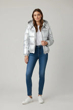 Front view of the silver puffer jacket open over a white top, paired with skinny jeans