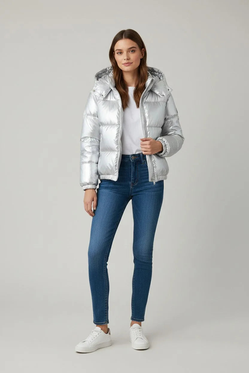 Front view of the silver puffer jacket open over a white top, paired with skinny jeans
