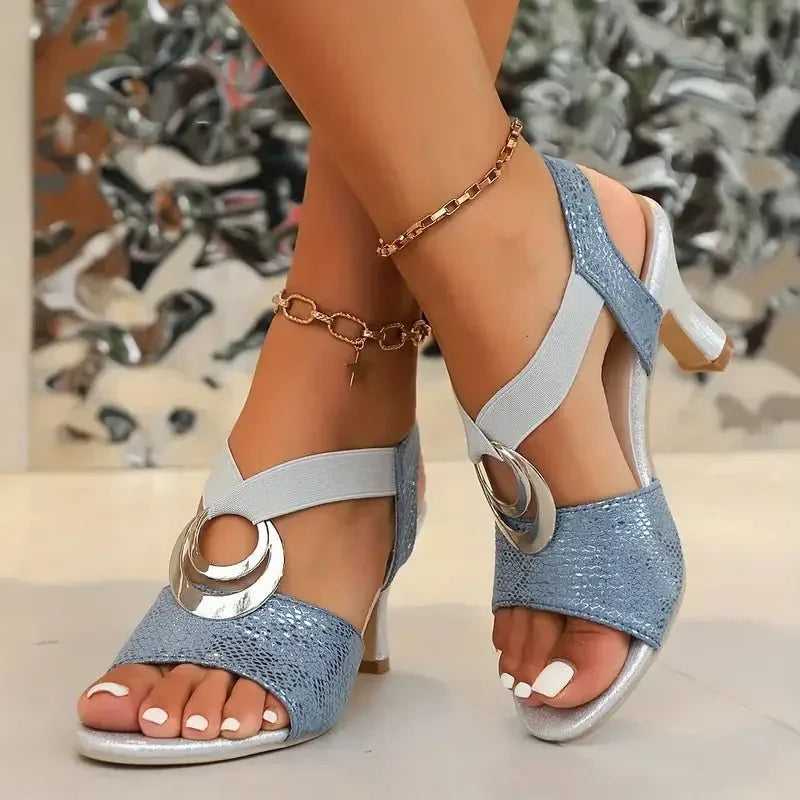 Light blue strappy sandals with silver block heel and crossover elastic straps, worn on feet