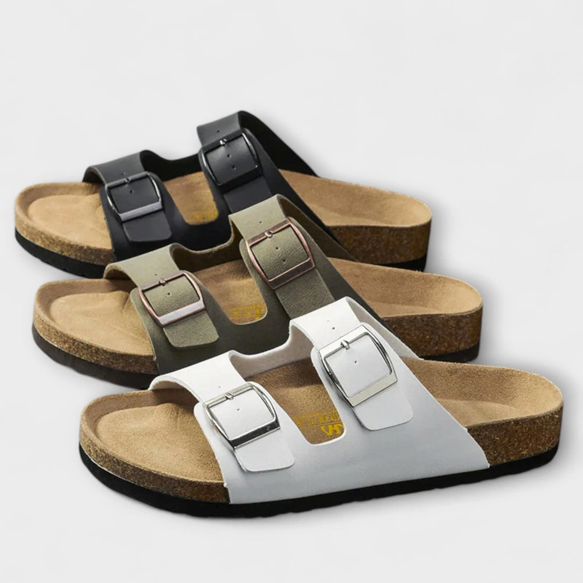 Three colourways of the two-strap buckle sandal lined up together in black, khaki and white