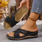 Overhead view of blush pink wedge sandals paired with denim, showing open-toe crossover design