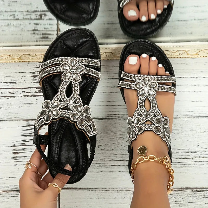 Top view of navy blue rhinestone sandals worn outdoors, showing the open toe and ankle strap closure
