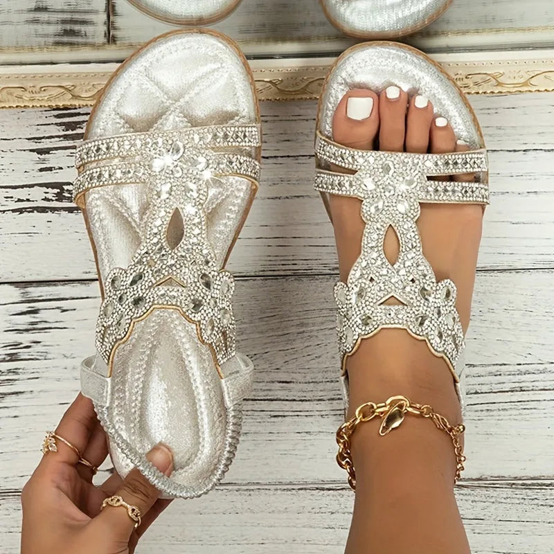 Close-up top view of teal rhinestone sandals worn on feet, highlighting the T-strap and cushioned sole