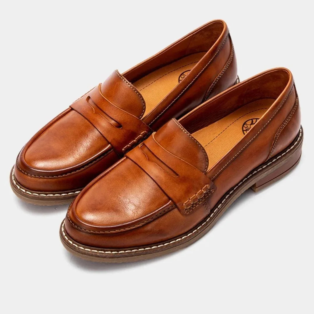 Pair of tan leather penny loafers shown together, polished finish with contrast stitching along the welt