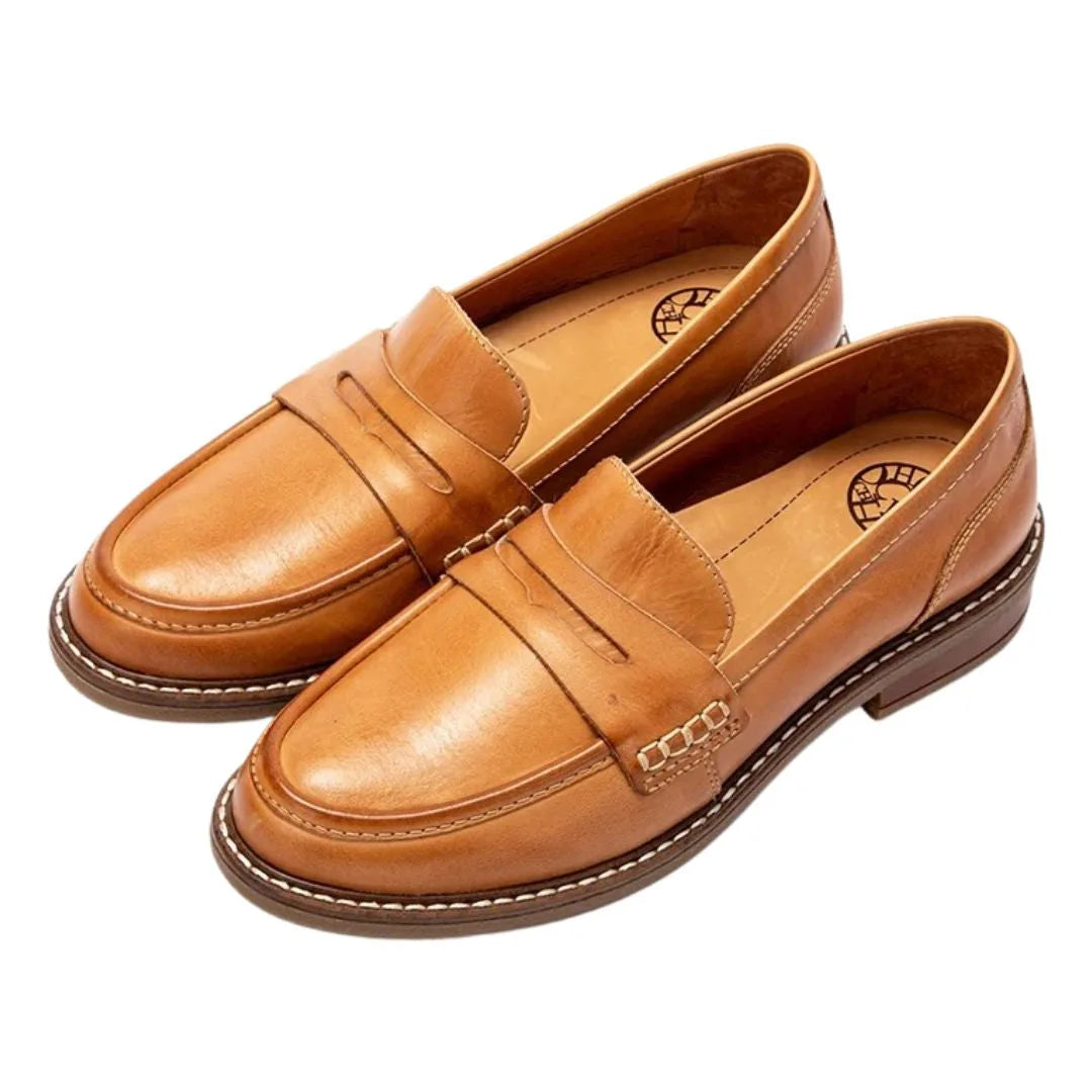 Angled front view of tan penny loafers showing the rounded toe and leather penny strap detail