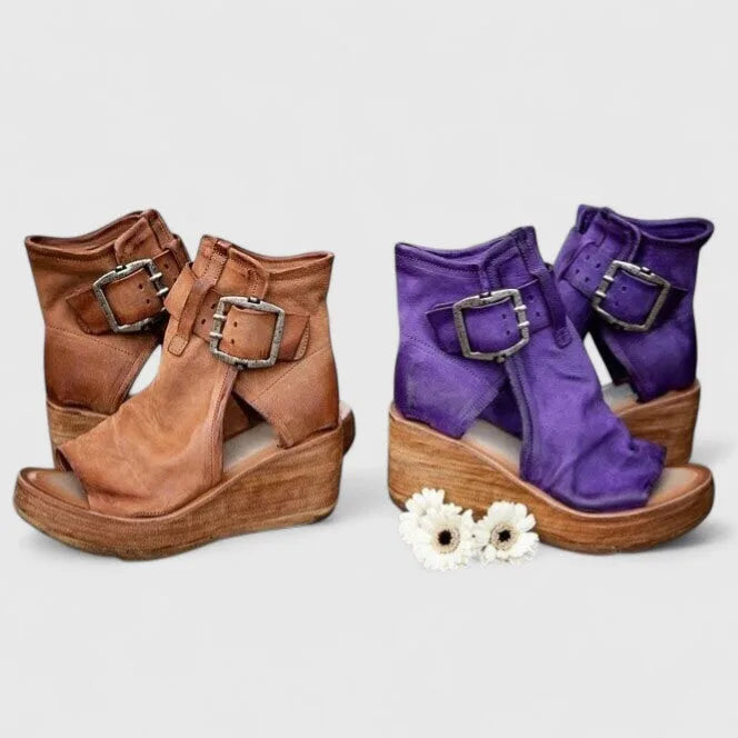 Tan brown and purple leather wedge booties paired together, showing double buckle ankle straps and cut-out sides