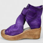 Side profile of purple leather wedge bootie with wide velcro ankle strap and open toe design