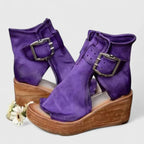 Close-up side view of tan leather wedge bootie showing buckle hardware, stitching detail and open toe
