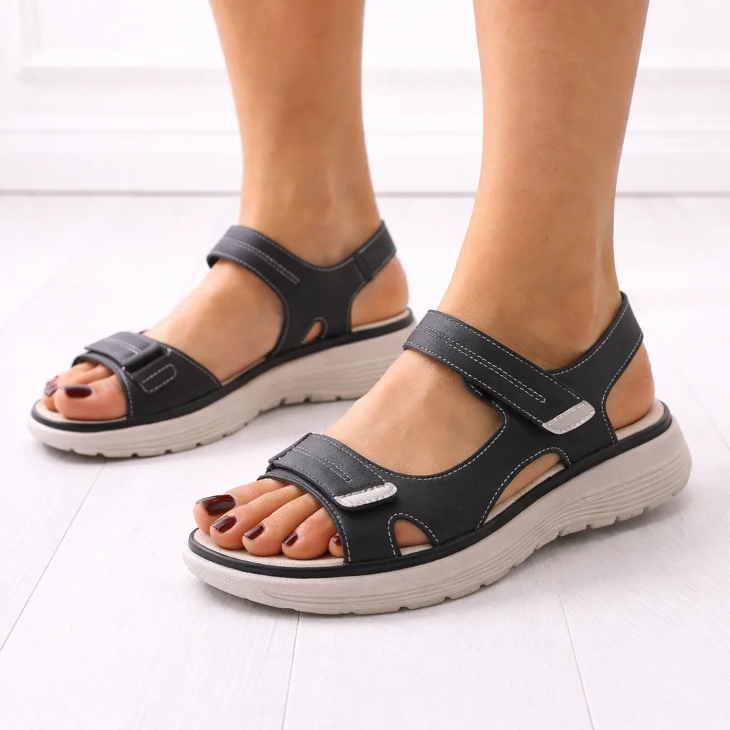 Side profile of black platform sandal showing dual adjustable straps, stitched detailing and thick ridged comfort sole