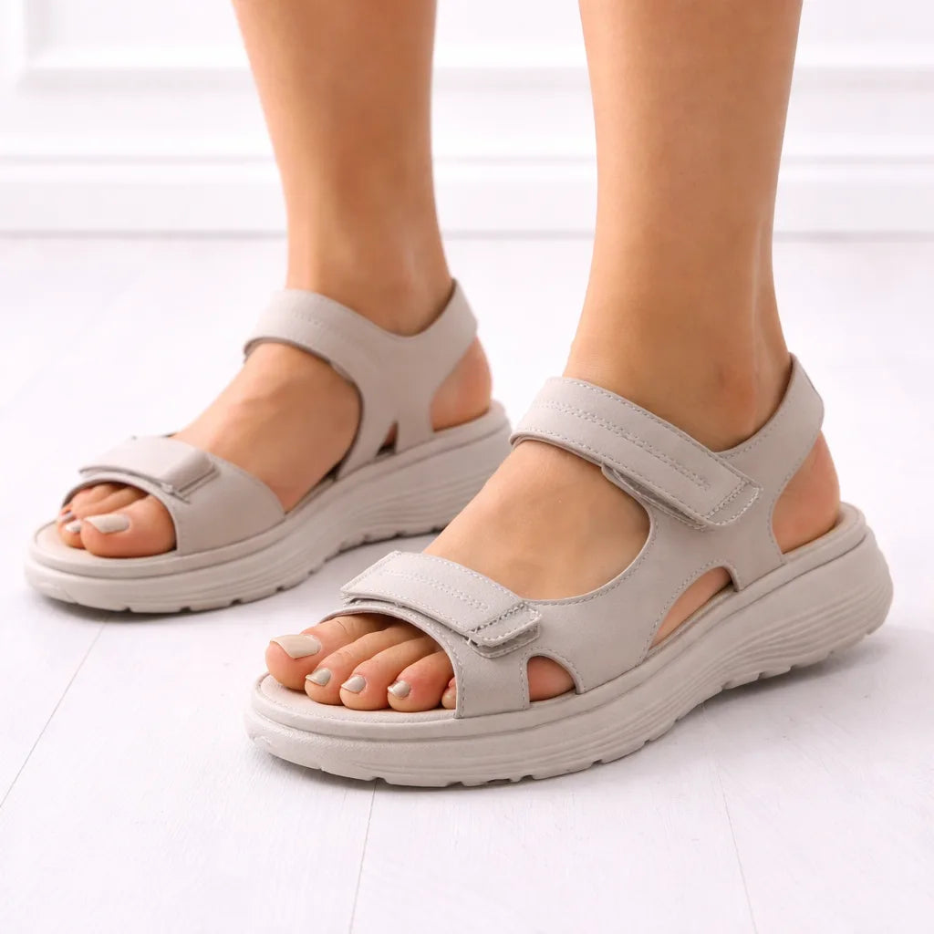 Close-up side angle of beige platform sandal with touch-fasten straps and matching neutral cushioned outsole