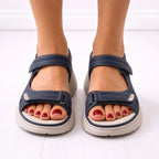 Front view of navy platform sandals worn on both feet, showing open-toe cut-outs and adjustable strap closures