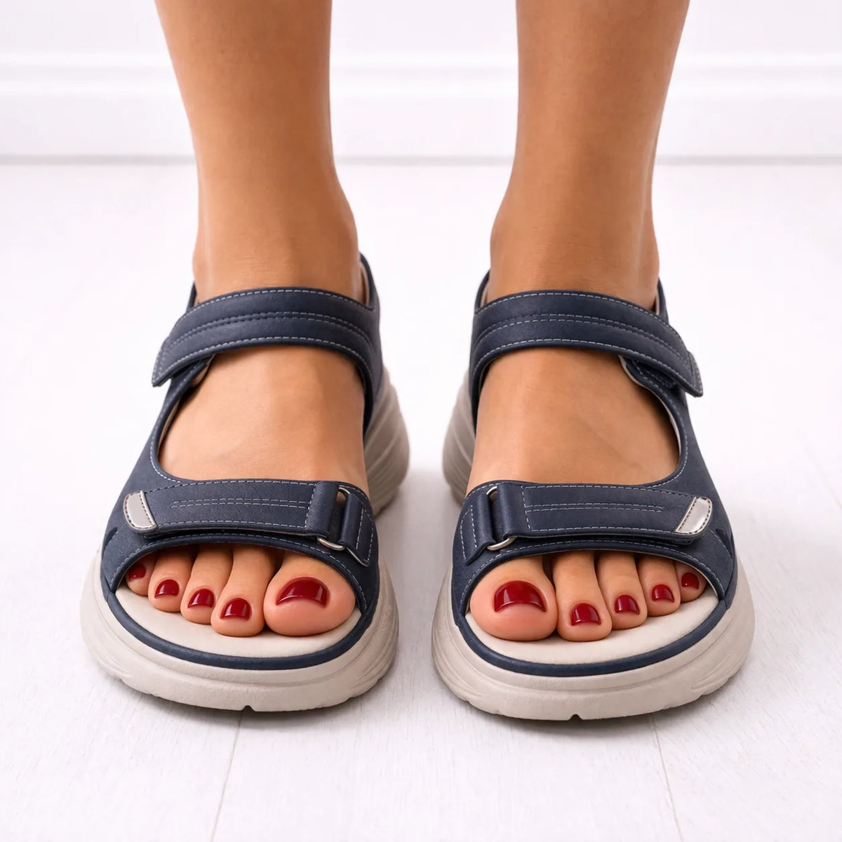 Front view of navy platform sandals worn on both feet, showing open-toe cut-outs and adjustable strap closures