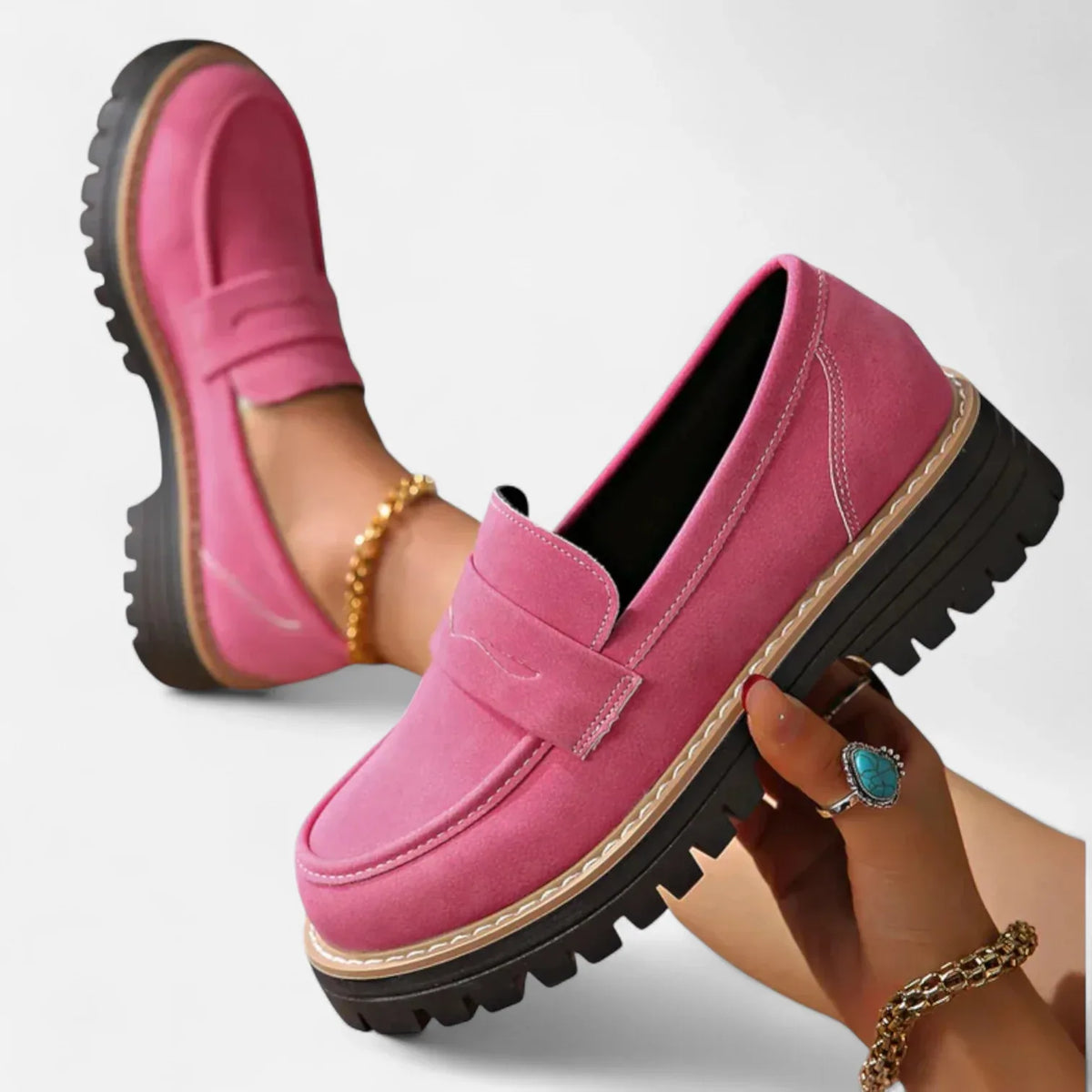 Hot pink suede penny loafer shown from the heel, highlighting the thick ridged black platform sole