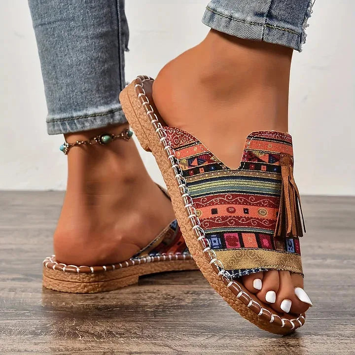 Close-up front view of multicolour tribal print sandals showing ankle strap and whipstitch edge detailing