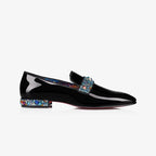 Close side view of black patent loafer highlighting the jewelled vamp strap and red-tinted outsole edge