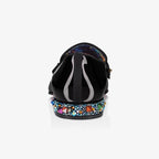 Rear view of a black patent loafer showing the galaxy-print heel lining and crystal-studded heel block