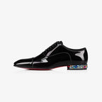 Side view of a black patent lace-up oxford shoe with cap toe detailing and a jewelled heel