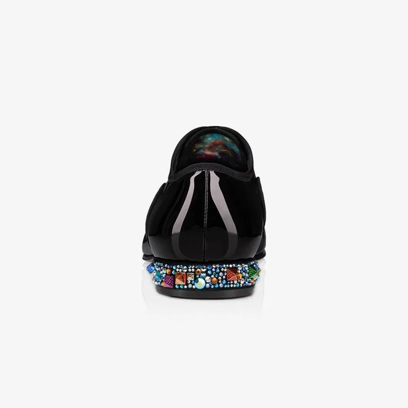 Close-up rear view of a patent loafer showing the colourful crystal and stud heel trim against black leather