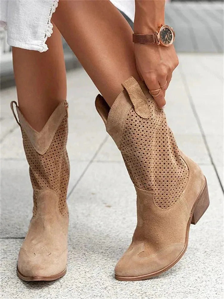 Tan suede mid-calf cowboy boots with perforated panel and contrast stacked heel, shown on model pulling boot on